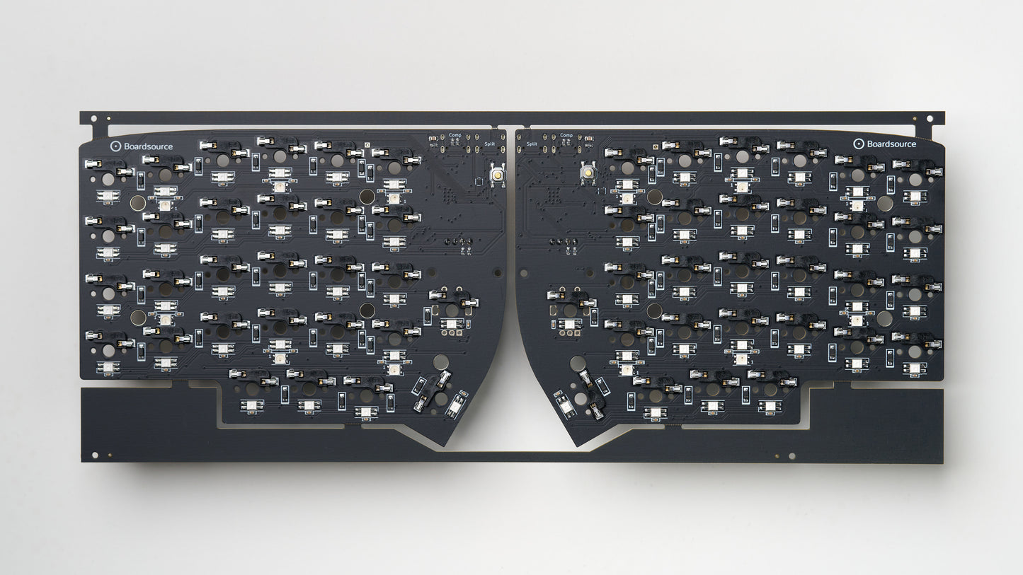 Top-down view of fully assembled Lily58 SMT PCB panel with hotswap sockets, dual USB-C ports, and per-key RGB LEDs on matte black board.