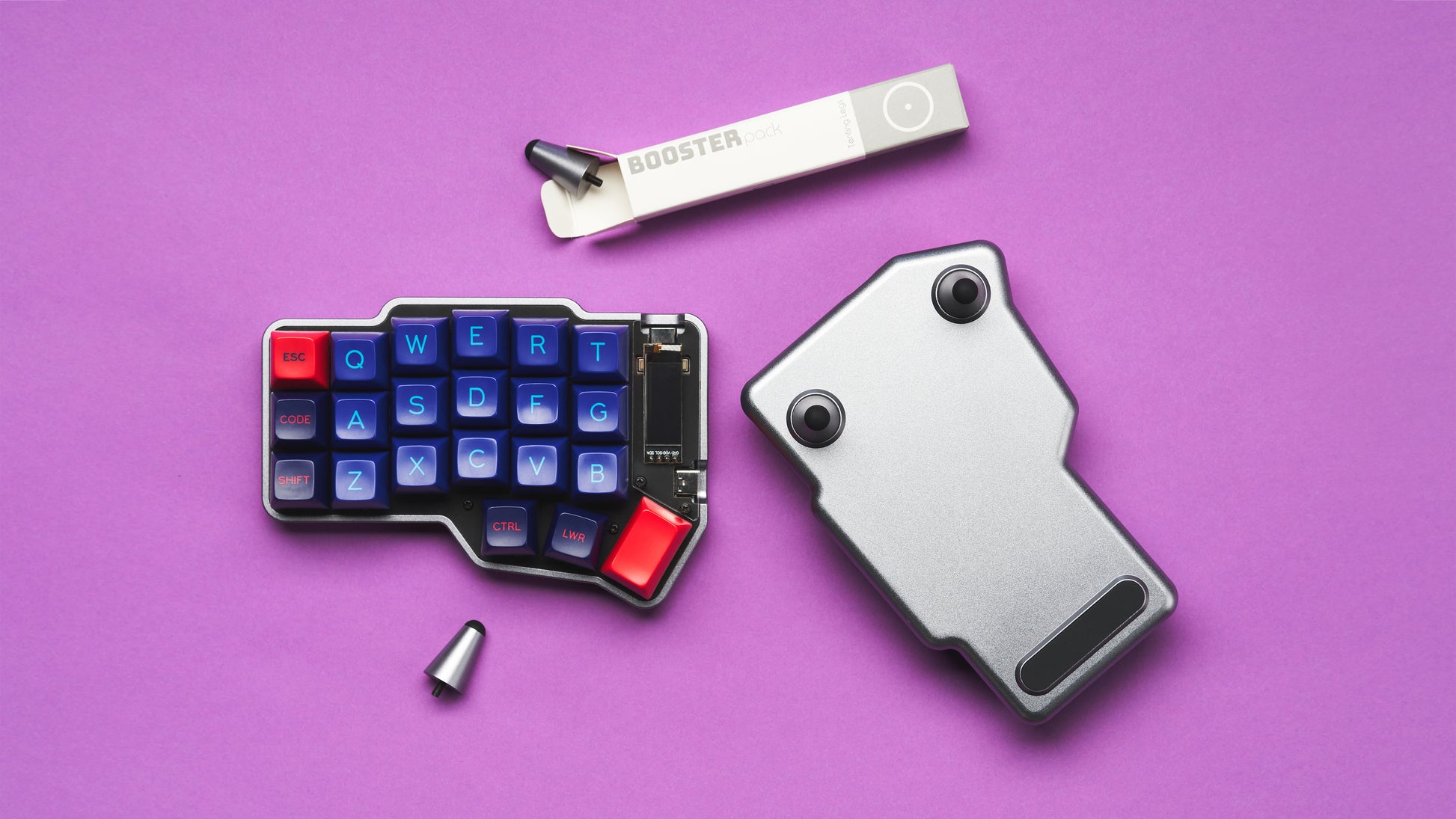 Partially assembled Unicorne keyboard kit laid out flat, showing the case halves, screws, and tools on a purple surface.