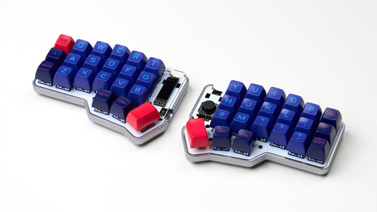 Unicorne split keyboard with Gray case and blue SA Laser Keycaps, with bright red spacebar keys shown on a white backdrop.