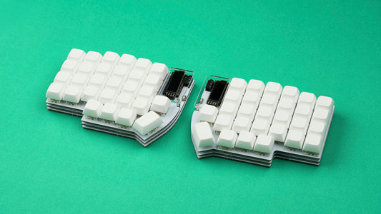 A fully assembled white Lily58 mechanical keyboard with white keycaps on a bright green background.