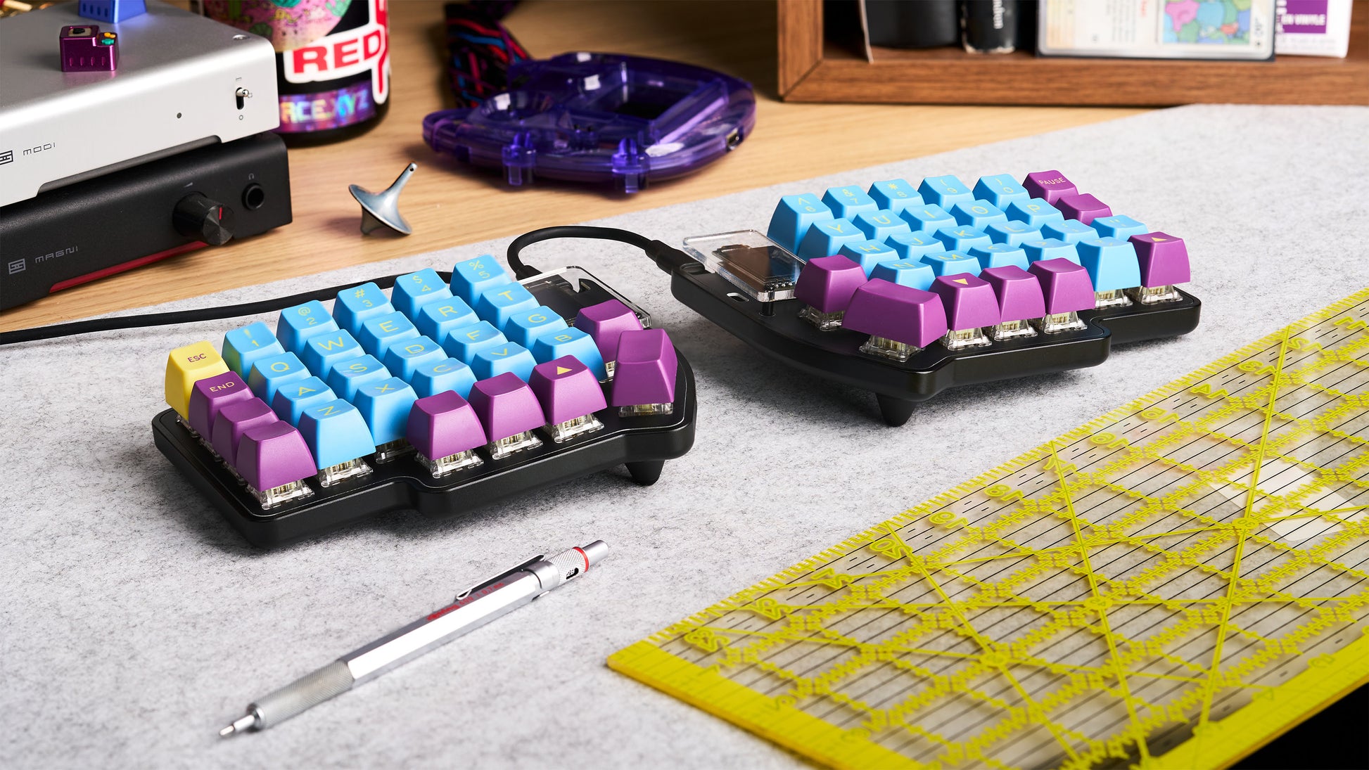 Lily Pad keyboard build with RGB keycaps and OLEDs, shown on a desk with retro accessories and grid mat.