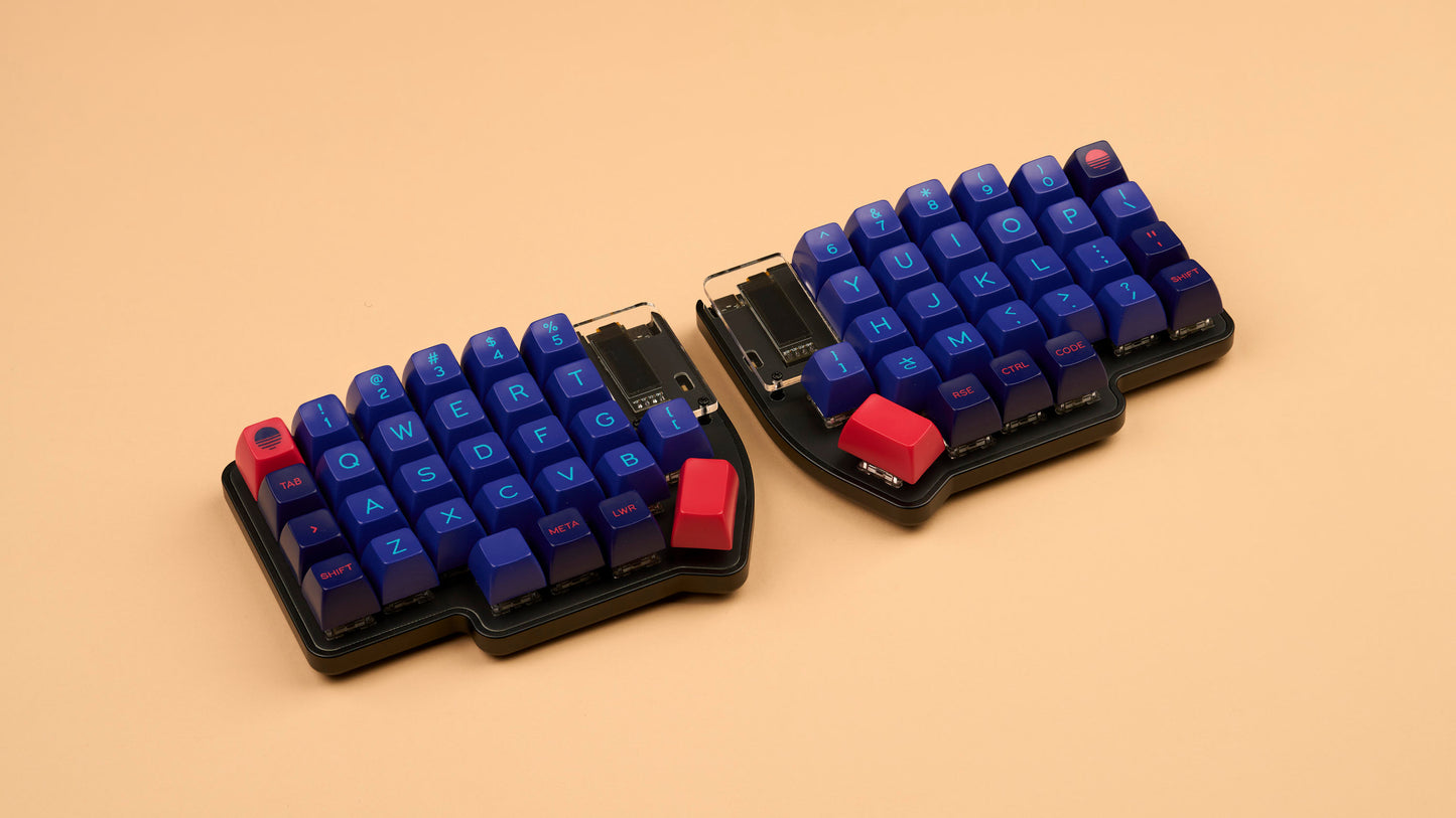 Lily Pad split 60% keyboard with black case and SA Laser keycaps on beige background
